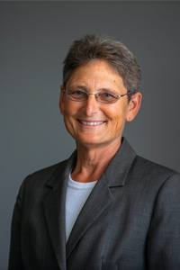 portrait of ruth siegfried smiling against grey background